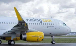 Billets annulés durant le Covid-19 : Vueling déterminé, à rembourser ses dettes Avion Vueling avec logo jaune et blanc sur piste d'aéroport.
