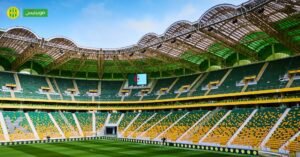 Stade Hocine Aït Ahmed avec sièges verts et jaunes, prêt pour la saison prochaine.
