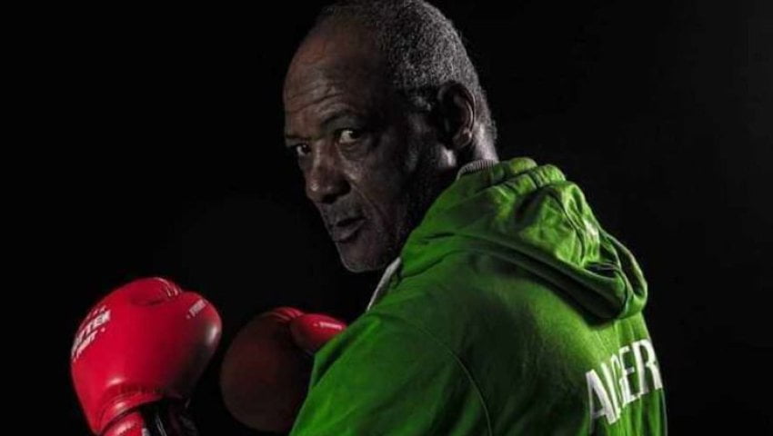 Portrait de Mustapha Moussa avec gants de boxe rouges et veste verte.