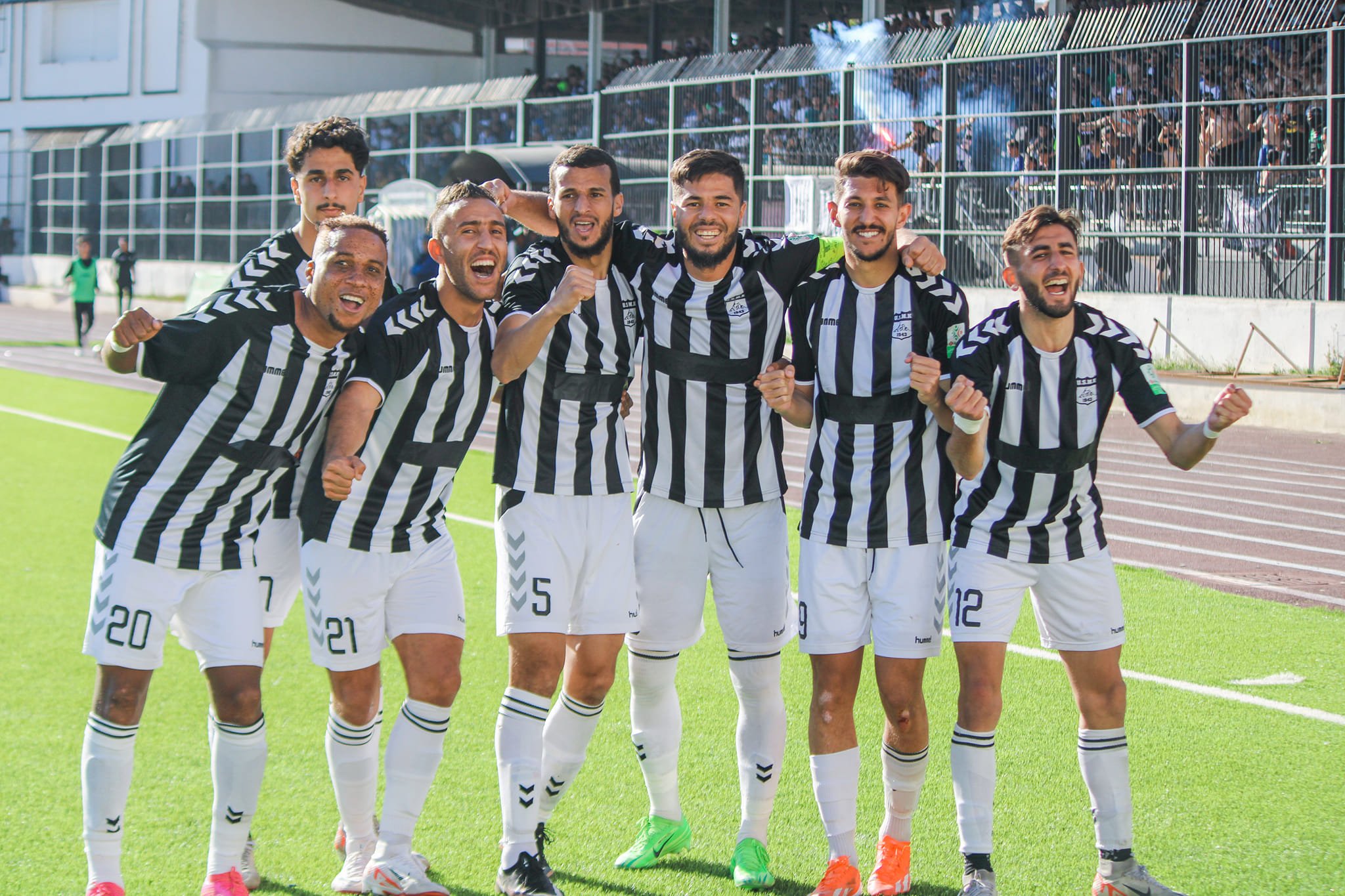 Groupe de joueurs de football USMK célébrant leur victoire.