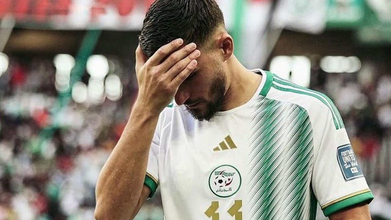 Houssem Aouar avec une expression de douleur sur le terrain.