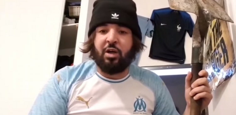 Mohamed Henni avec un marteau dans une pièce intérieure.