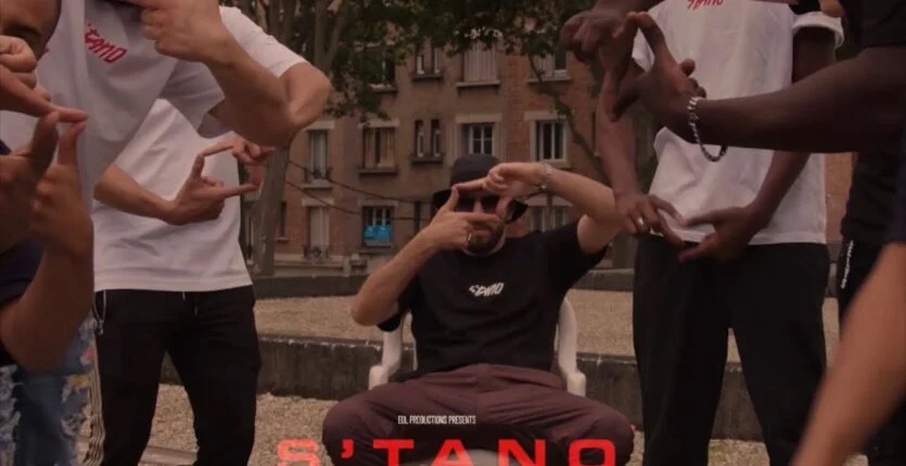 Artiste algérien en train de performer avec un groupe dans un parc urbain.