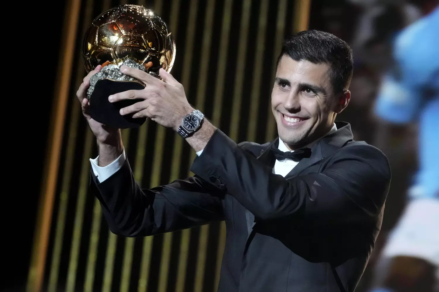 Vinicius Jr souriant avec le Ballon d'Or lors de la cérémonie 2024.