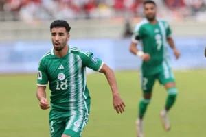 Footballeur en maillot vert en pleine course sur le terrain.