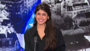 Censure en direct : Rima Hassan coupée par BFMTV après ses critiques sur Israël Rima Hassan souriante lors d'une émission télévisée en direct.