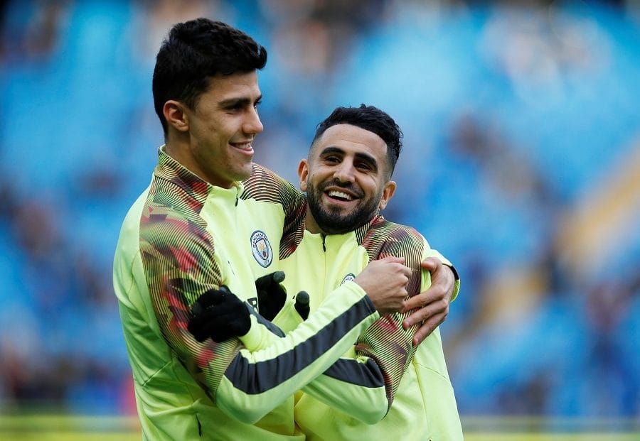 Riyad Mahrez et un coéquipier en célébration sur le terrain de football.