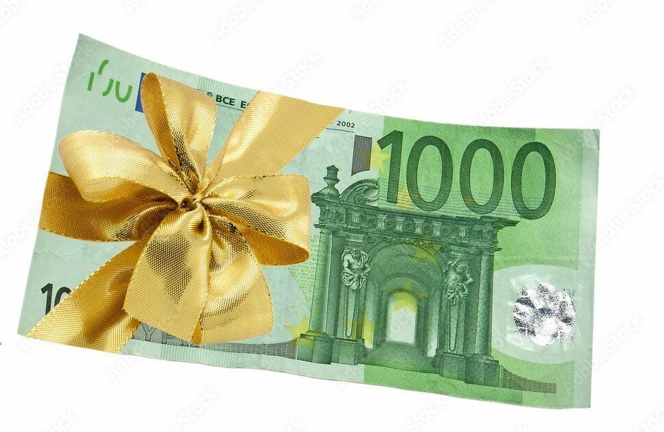 Billet de 1000 euros décoré d'un ruban doré pour célébration ou cadeau.