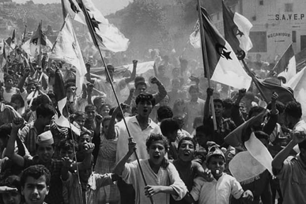 Jeunes manifestants algériens brandissant des drapeaux lors d'une manifestation historique.