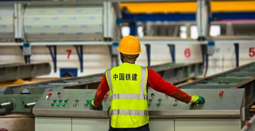 Ouvrier dans une usine ferroviaire en Algérie avec casque jaune.