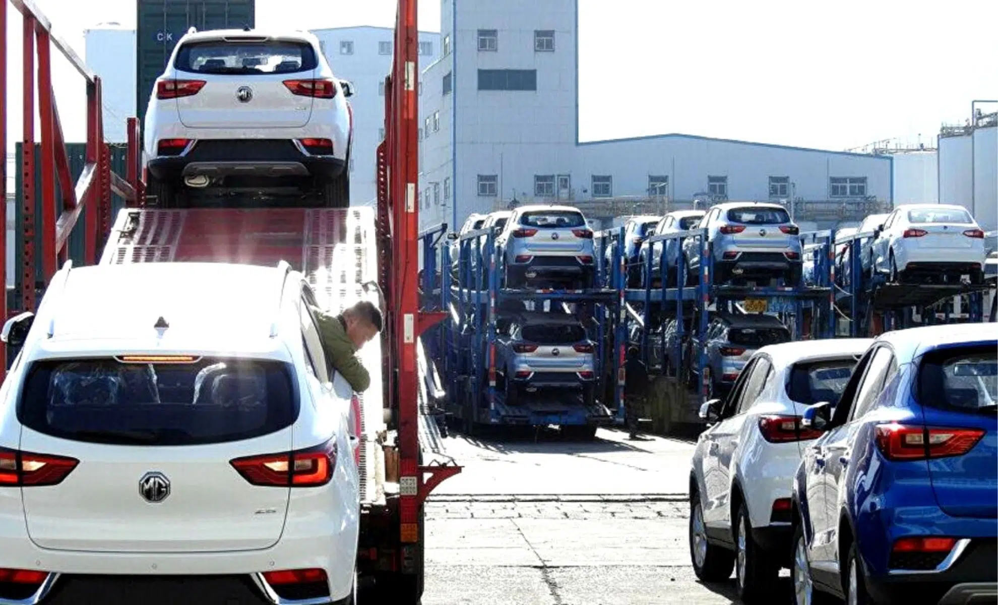 Transporteur chargeant une voiture neuve sur un camion de livraison.