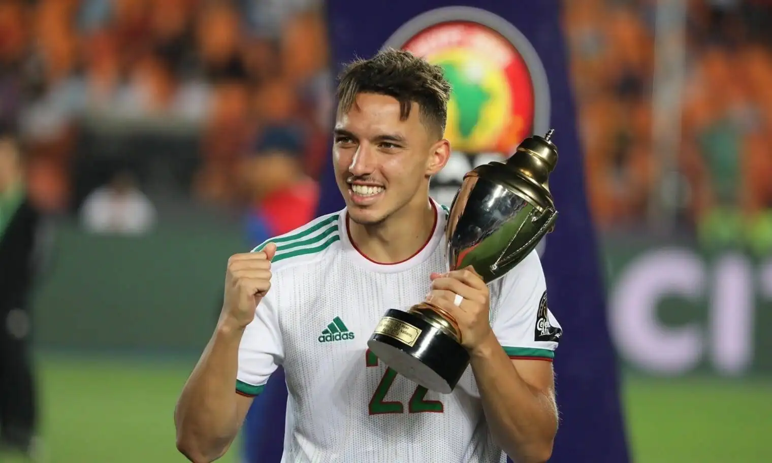 Ismaël Bennacer souriant avec le trophée de la CAN 2021.