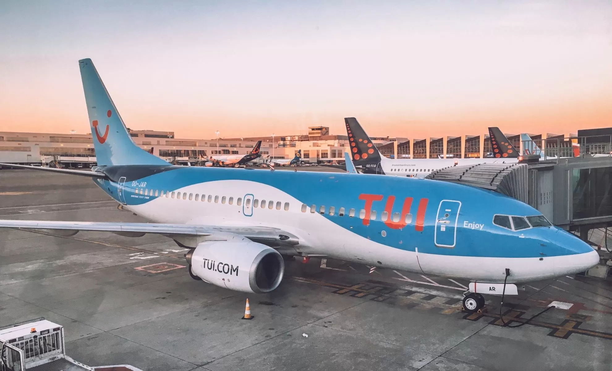 Avion TUI Fly bleu et blanc à l'aéroport lors du coucher du soleil.