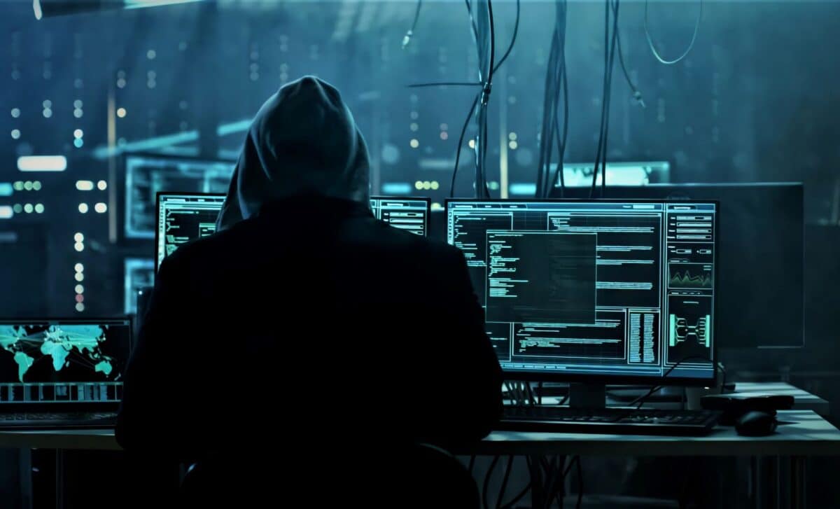 Hacker en action dans une salle de cybersécurité sombre et high-tech.