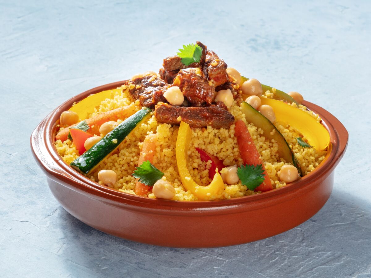 Couscous algérien avec légumes et viande dans un plat en terre cuite.