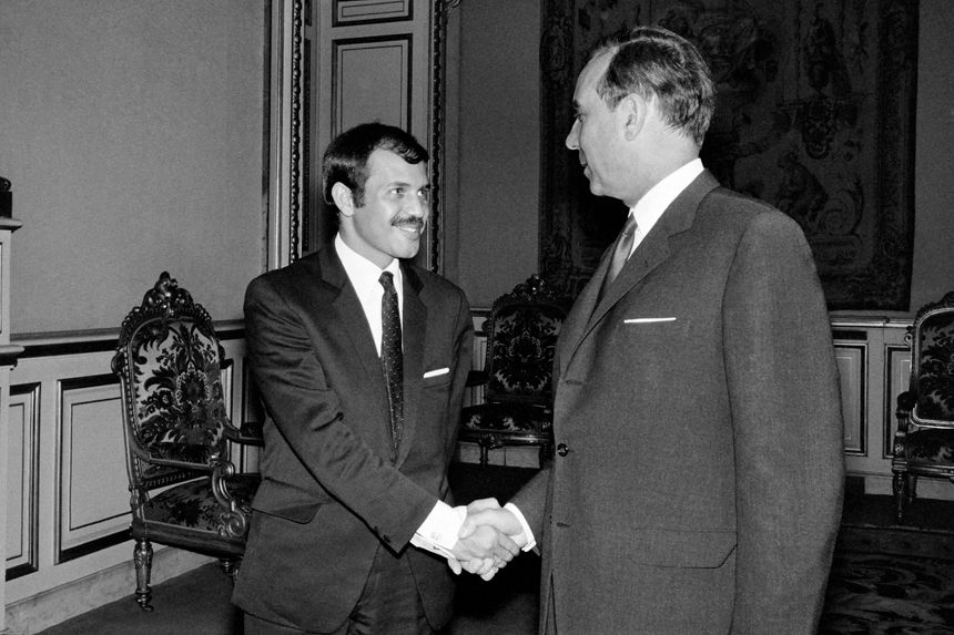 France–Algérie : vers un changement clé de l’accord de 1968 Deux hommes en costume se serrent la main dans une salle élégante.