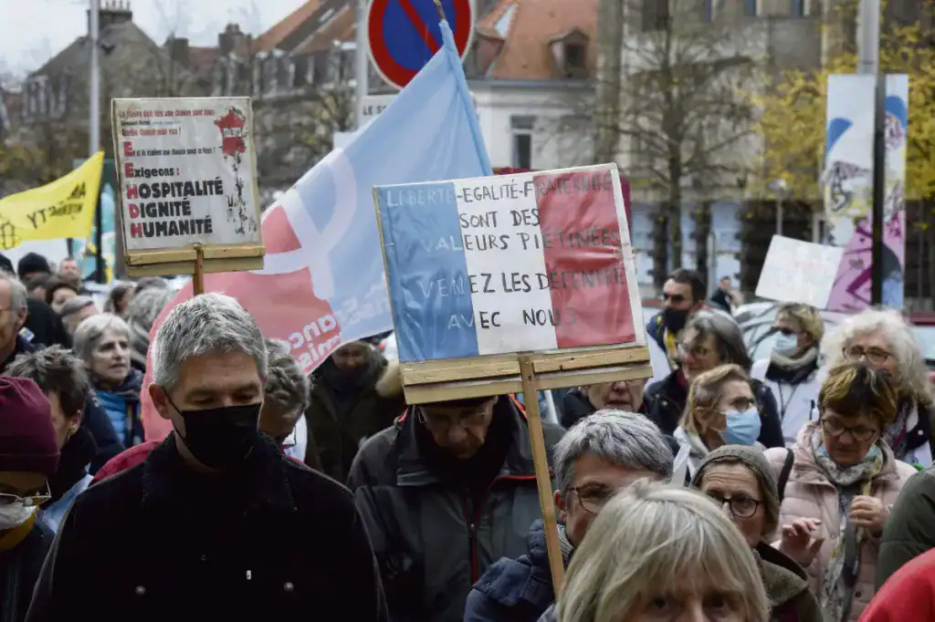 Manifestation avec des pancartes et drapeaux pour la liberté et l'égalité.