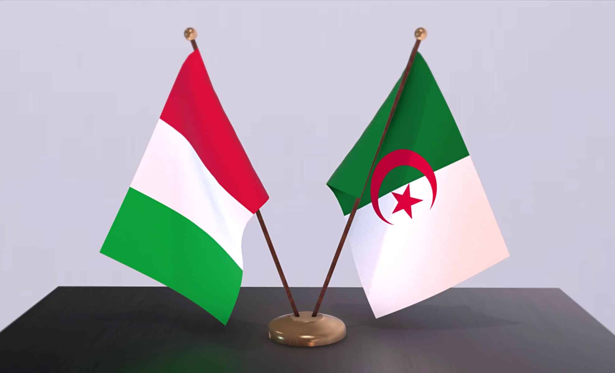 Drapeaux de l'Algérie et de l'Italie côte à côte sur une table.