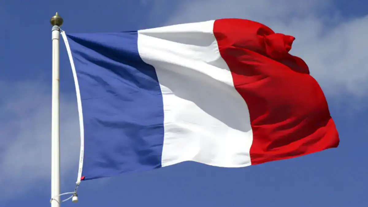 Drapeau français flottant dans le ciel avec nuages.