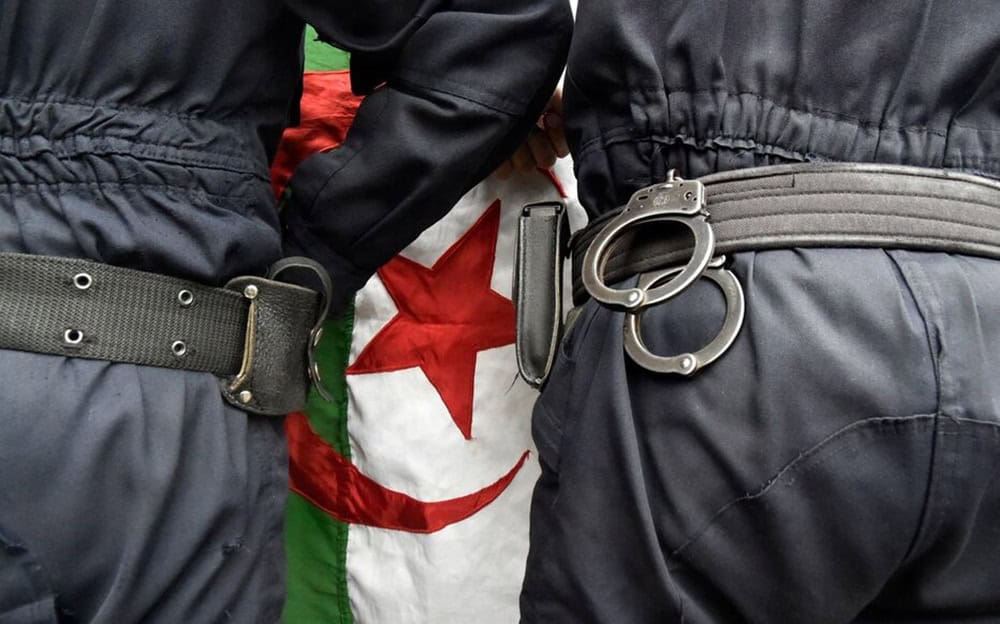 Policiers avec drapeau algérien en arrière-plan.