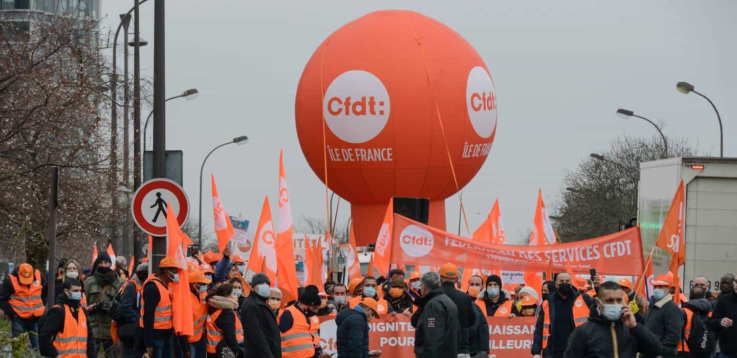 Crise titre de séjour en France : l’ANEF au cœur d’un système à bout Manifestation avec drapeaux et ballons syndicaux en France.