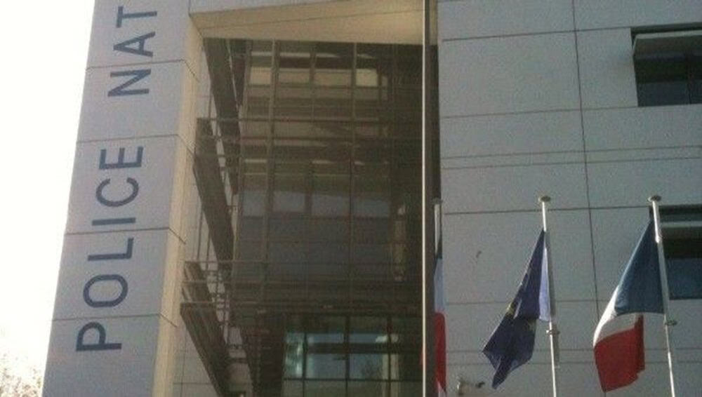 Bâtiment de la police à Bordeaux avec drapeaux français et européens.