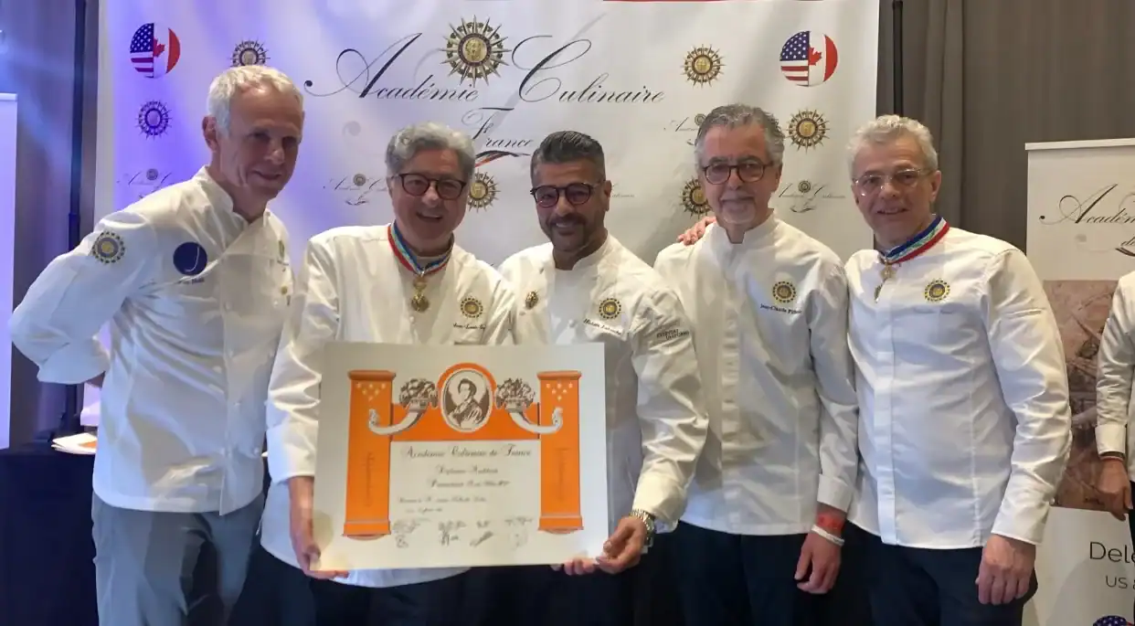 Groupe de chocolatiers en uniforme lors d'une cérémonie.