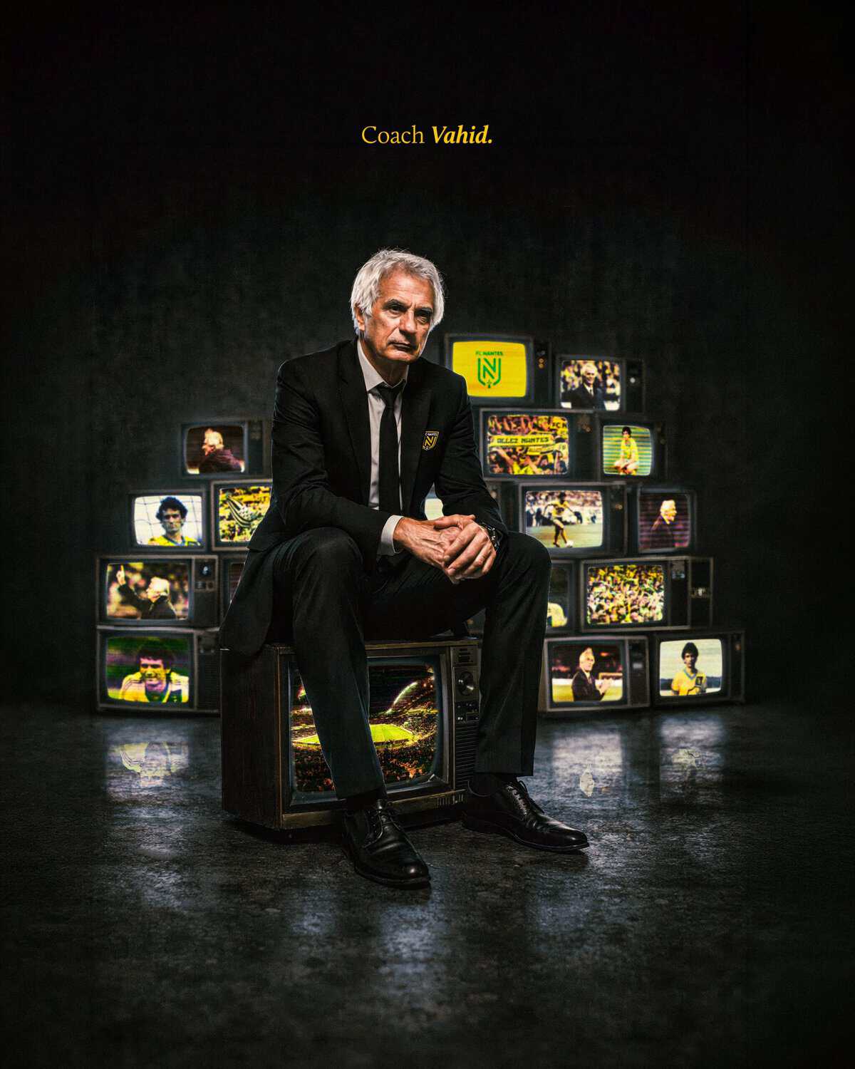 Vahid Halilhodzic assis devant des écrans de télévision avec des images de football.