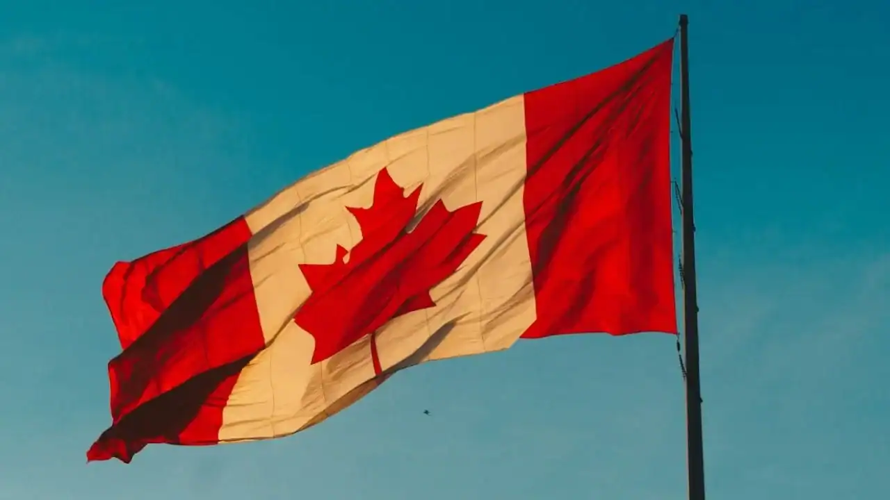 Drapeau du Canada flottant dans le ciel bleu clair.