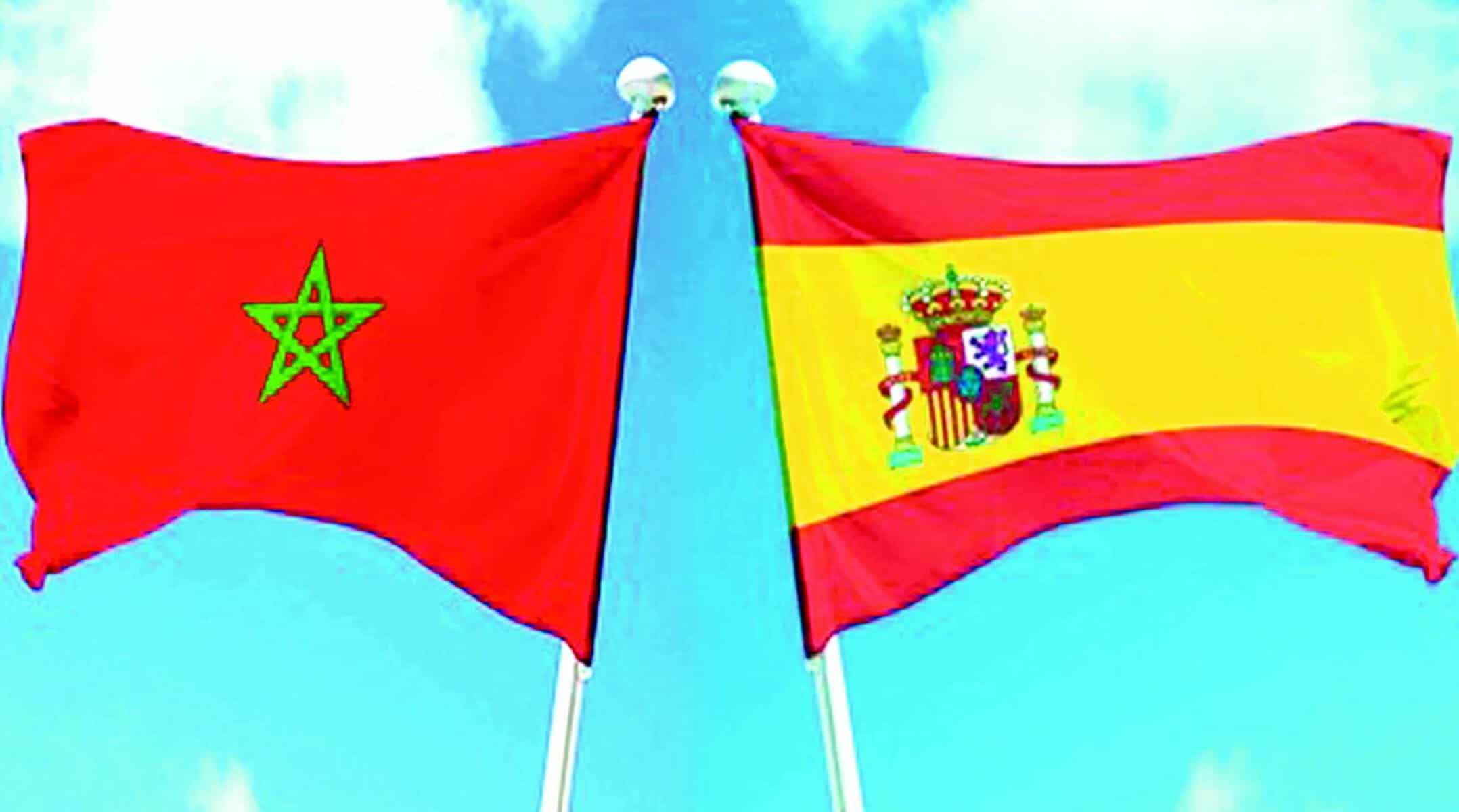 Drapeaux du Maroc et de l'Espagne flottant dans le ciel bleu.