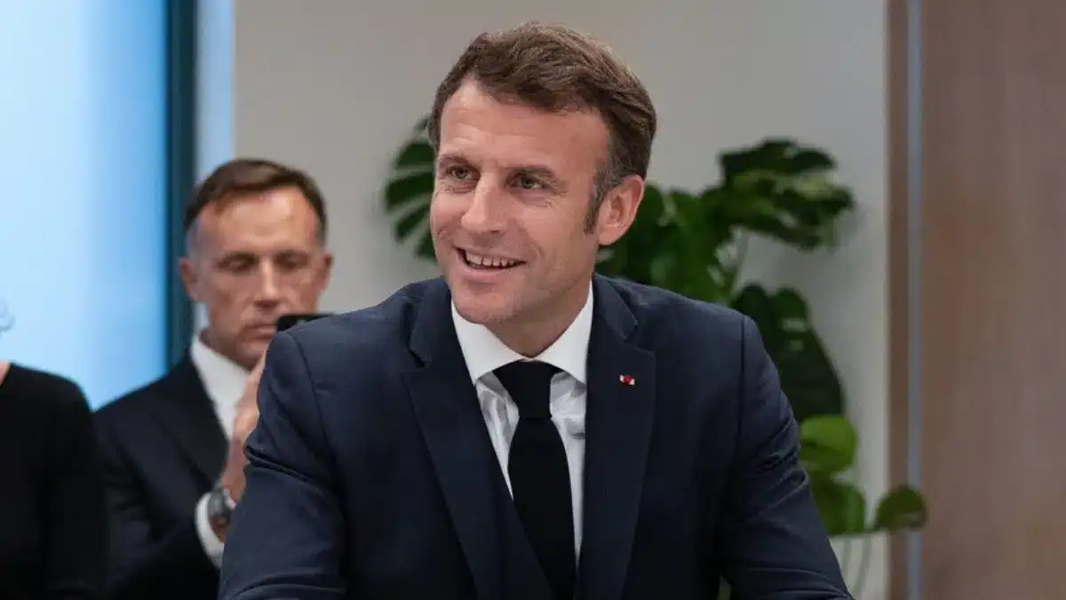 Nouvelle stratégie de la France envers l'Algérie révélée Emmanuel Macron souriant lors d'une rencontre officielle.