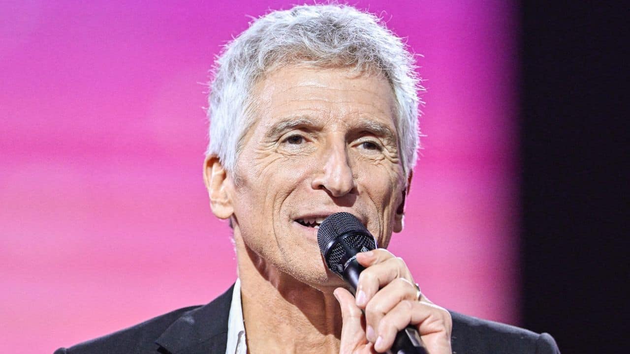 Nouvelle incidence algérienne dans une dispute française Homme âgé avec cheveux gris parlant dans un micro lors d'un événement.