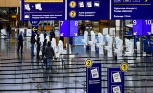 Passagers à l'aéroport utilisant les bornes d'enregistrement.