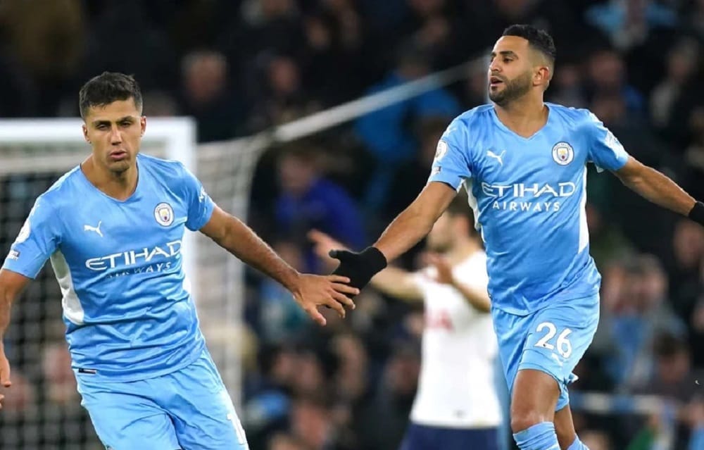 Riyad Mahrez en action avec un coéquipier lors d'un match de football.