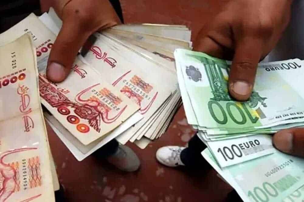 Main tenant des billets de banque en dinar algérien et euro.