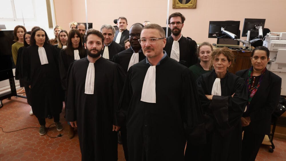 Groupe d'avocats en robe dans une salle d'audience.