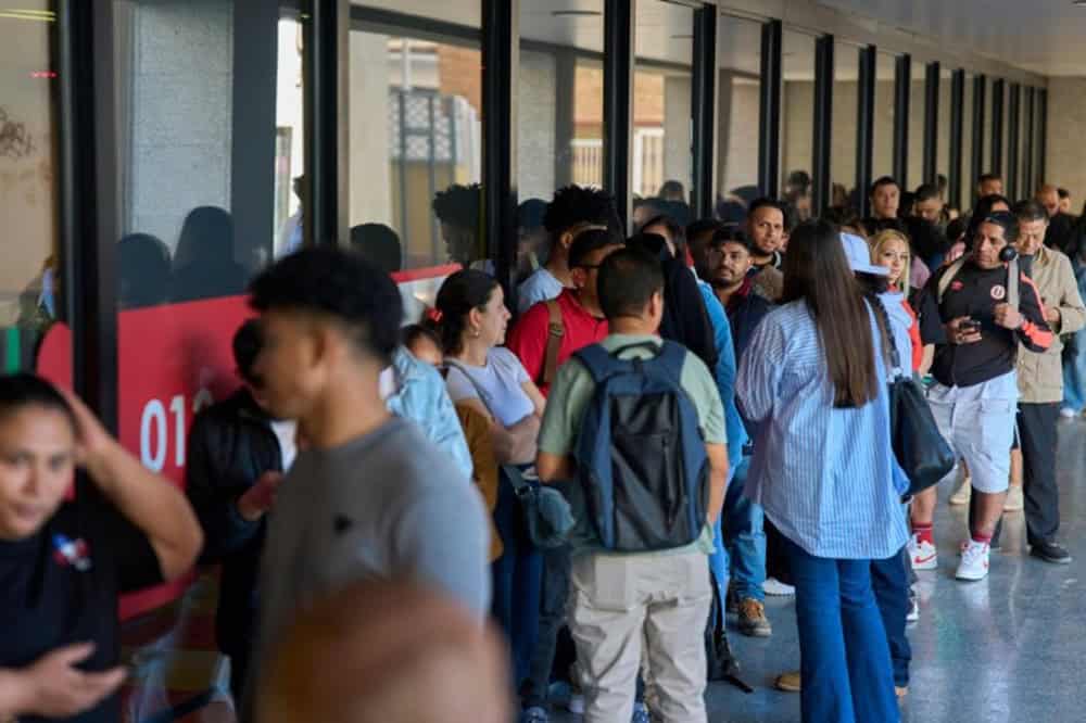 Groupe de migrants faisant la queue dans un centre d'accueil en Espagne.