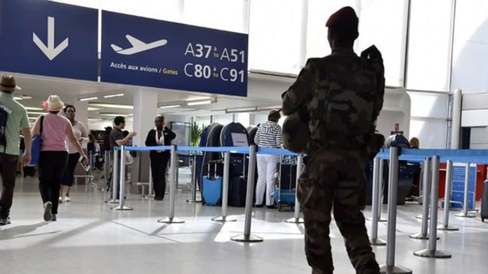 Personne en uniforme militaire dans un aéroport parisien en grève.