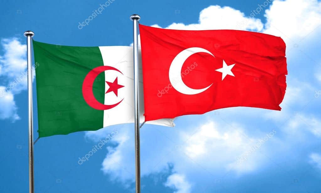 Drapeaux de l'Algérie et de la Turquie flottant dans le ciel.