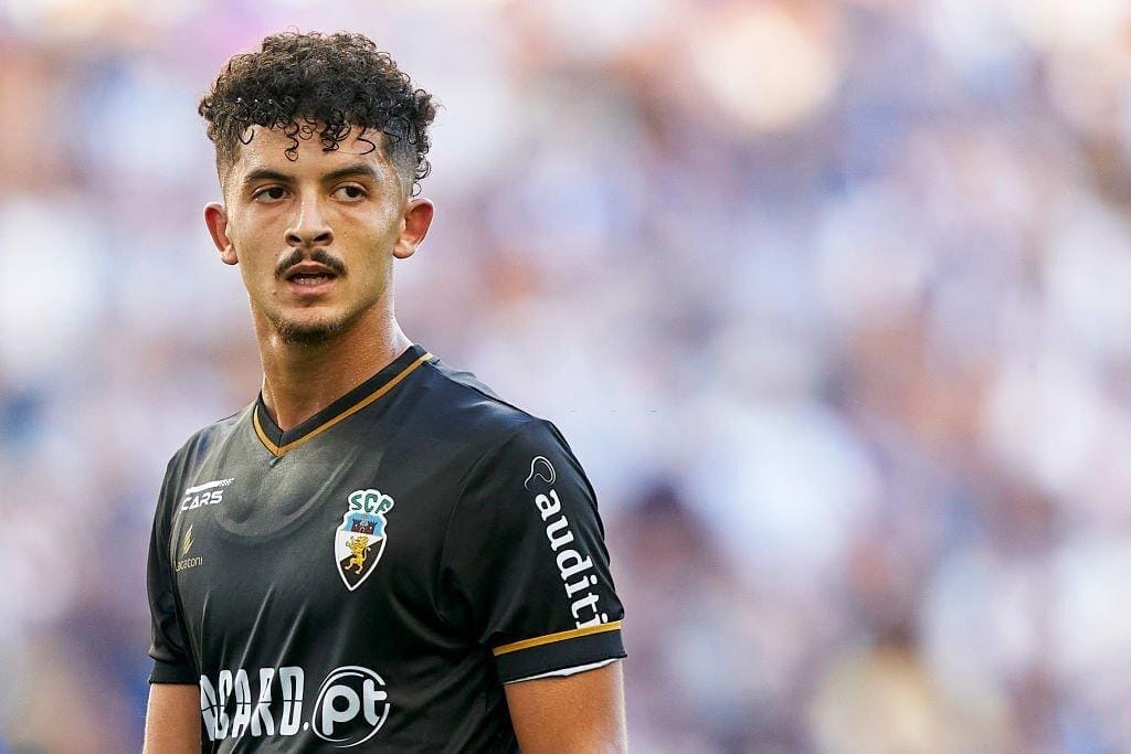 Bachir Belloumi joueur de football en maillot noir sur le terrain.