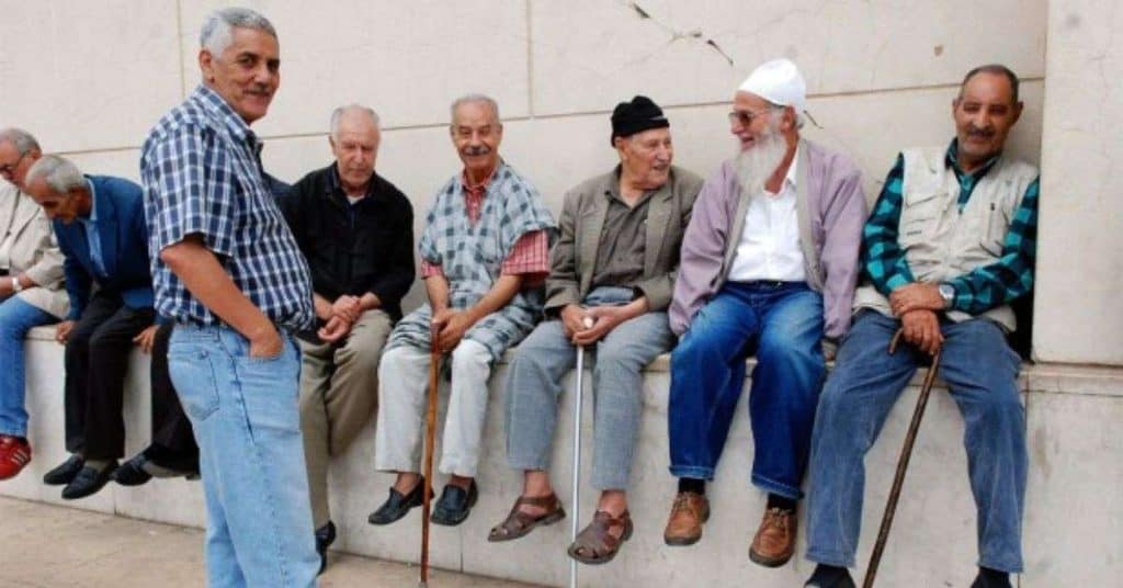 Groupe de retraités algériens discutant et socialisant.