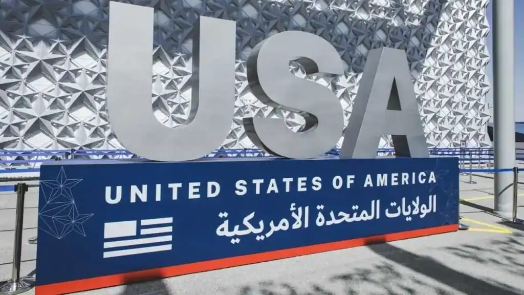 Logo USA avec panneau d'information en anglais et arabe.