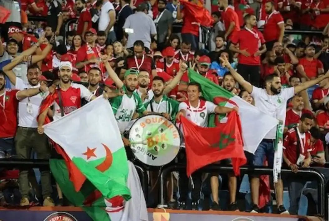 Supporters algériens avec drapeaux lors d'un match de football.