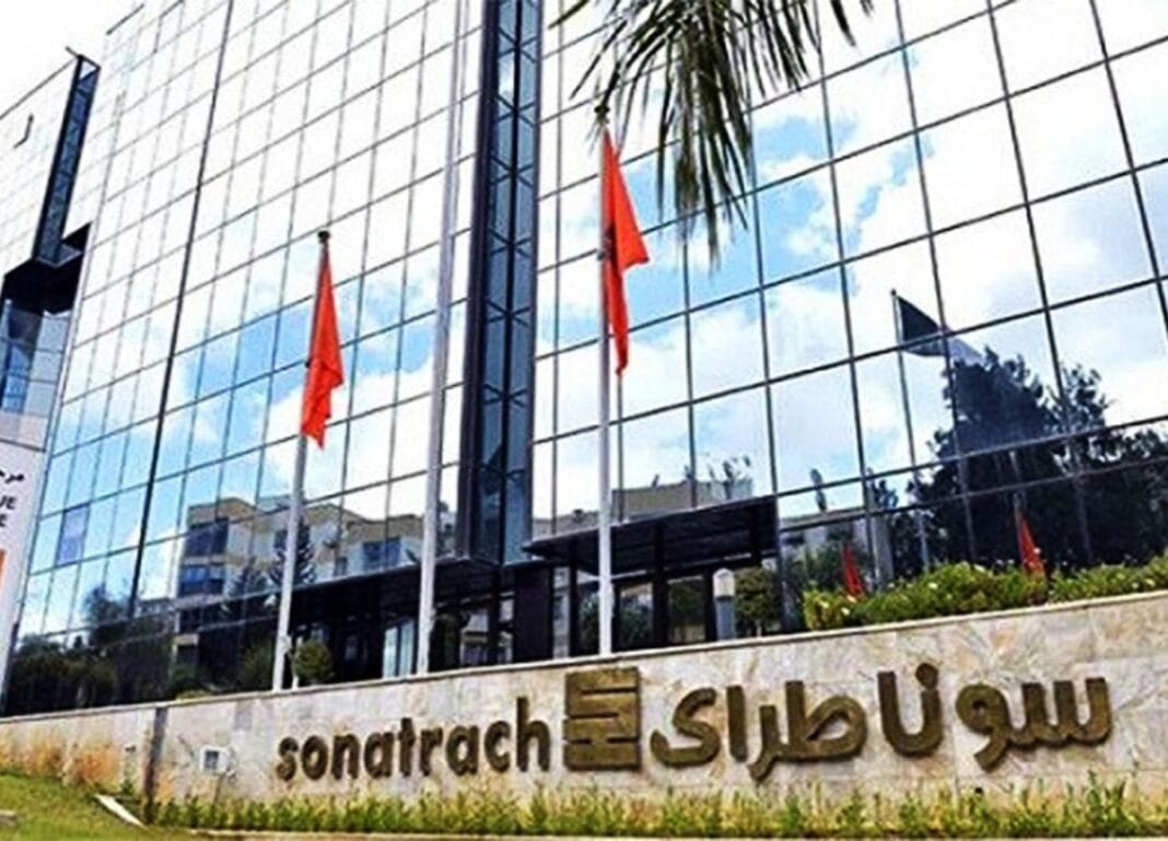 Bâtiment moderne de Sonatrach avec drapeaux rouges et façade en verre.