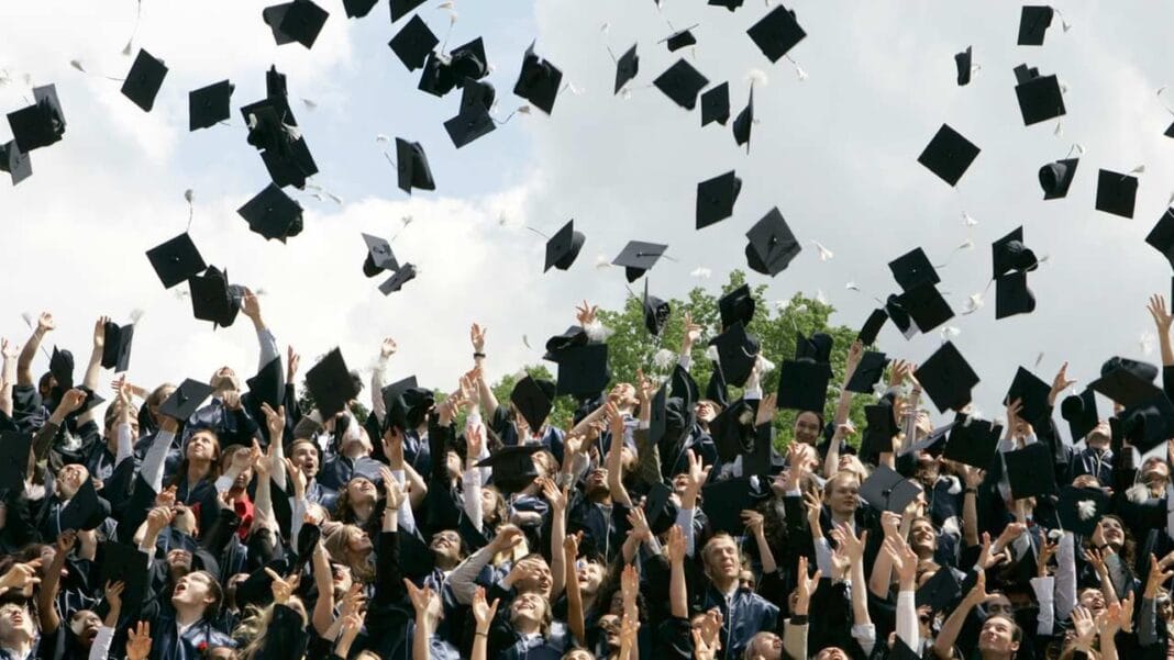 Étudiants en graduation lançant leurs chapeaux lors d'une cérémonie de fin d'études.