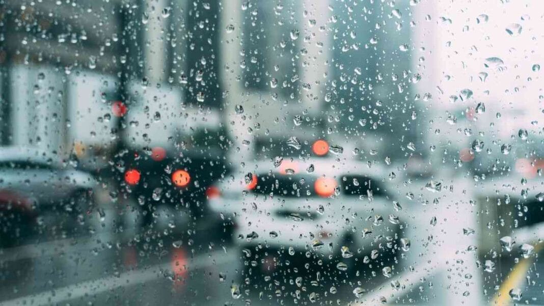 Météo Algérie : retour de la pluie ce mardi 12 avril Fenêtre embuée avec gouttes de pluie et trafic urbain en arrière-plan.