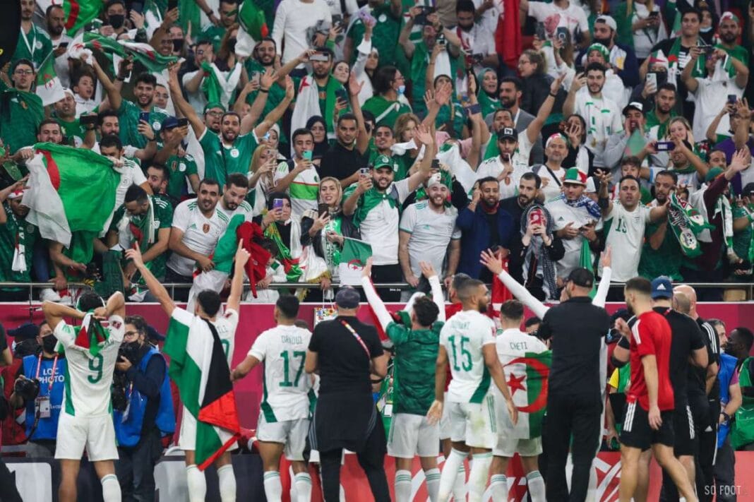 L’Algérie victime de complot face au Cameroun Supporters algériens en célébration avec drapeaux lors d'un match.