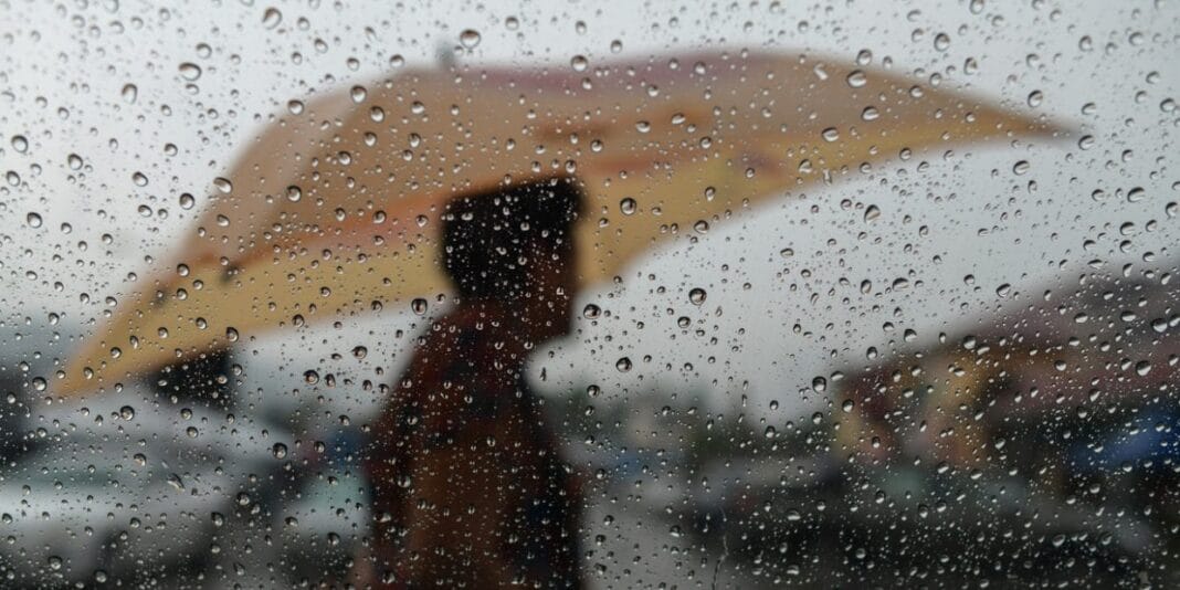 Météo Algérie : pluies orageuses au niveau de 11 wilayas en ce début de semaine Personne avec parapluie sous la pluie en Algérie.