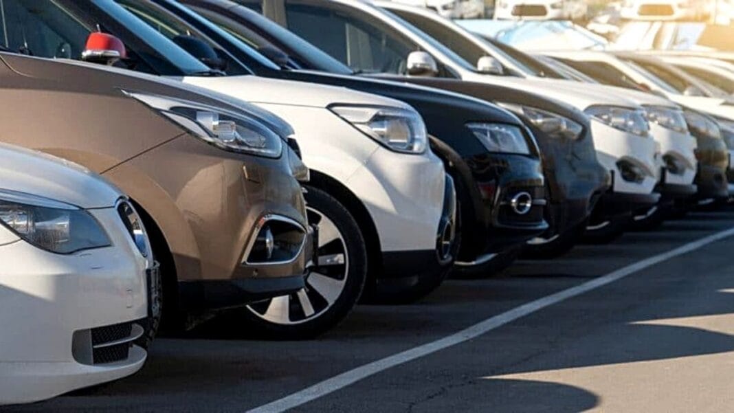 Ligne de voitures modernes garées dans un parking en plein jour.