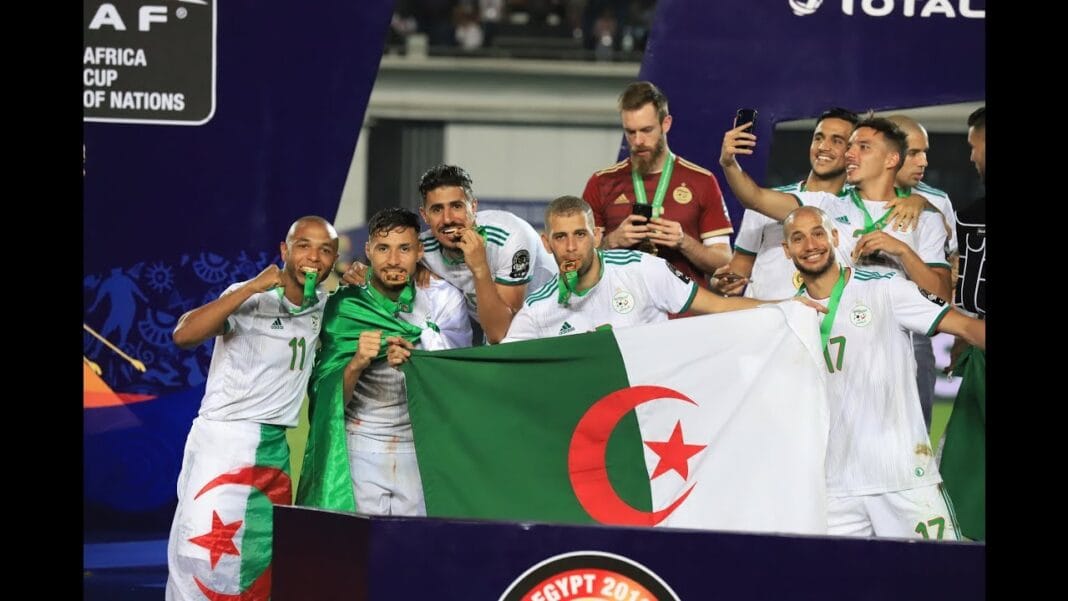 Coup d’autorité ! Un entraîneur européen réprimande un cadre de l’équipe d’Algérie L'équipe d'Algérie célèbre sa victoire avec le drapeau national.
